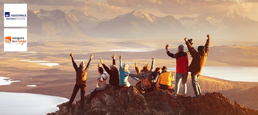 nueve personas en una montaña levantando los brazos