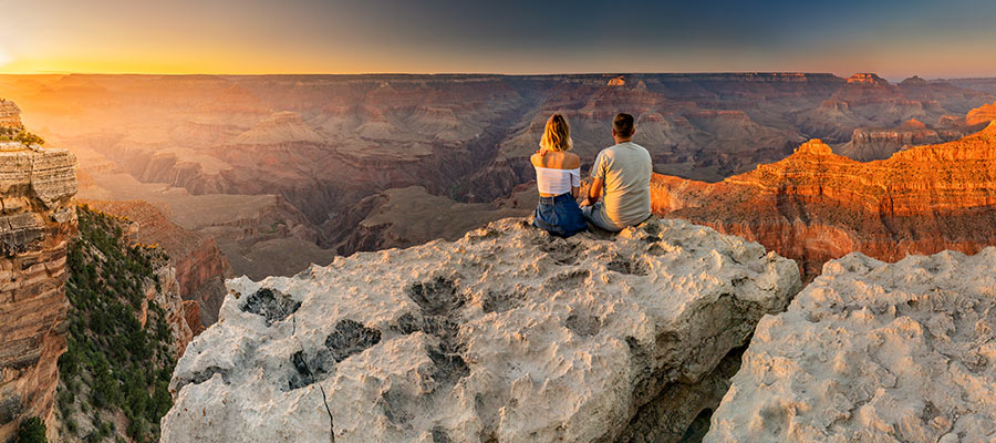 Una pareja mirando el atardecer desde una montaña