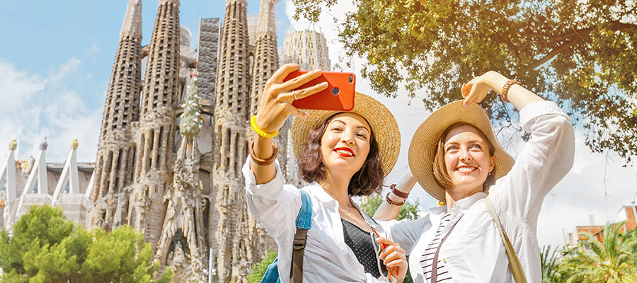 Dos mujeres sacándose una foto con la sagrada familia de fondo
